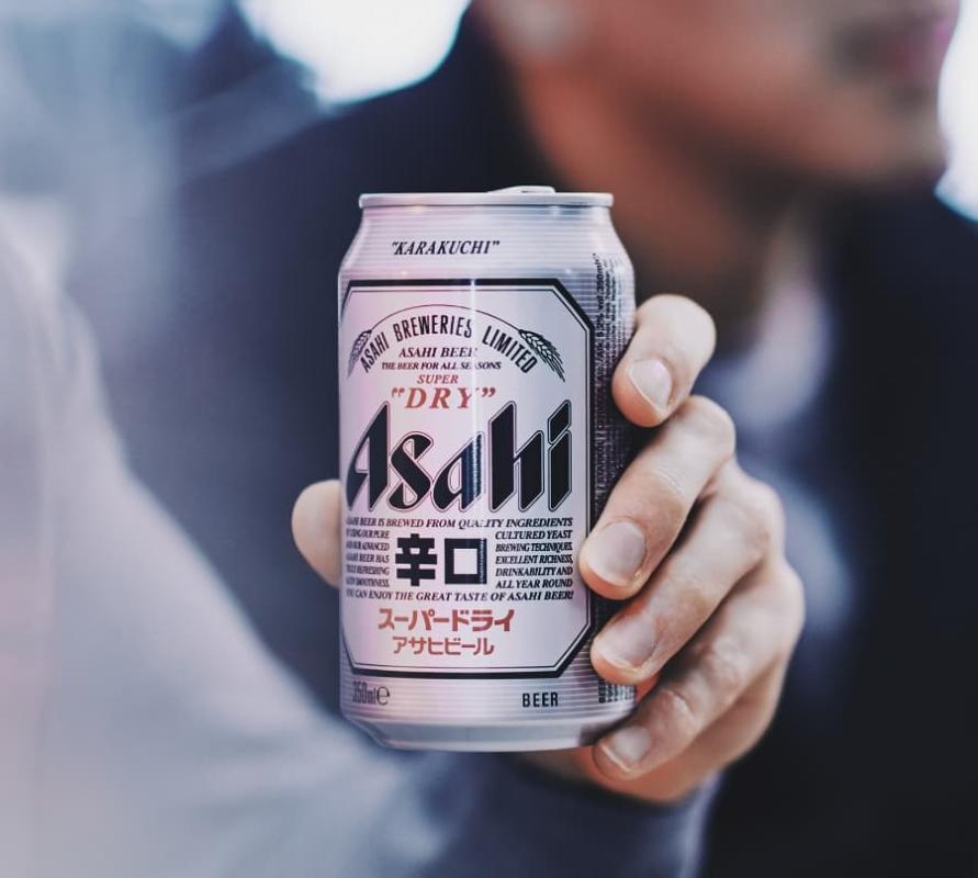 Hang holding Asahi beer can